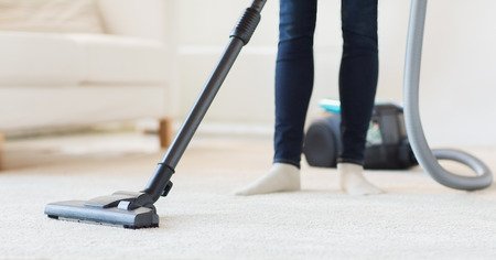 Woman Vacuum Cleaning a Carpet