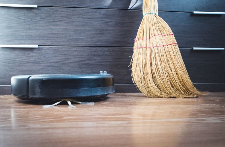 Robot Vacuum Next to a Broom